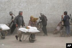 Masyarakat menerima jatah pangan di Kabul, Afghanistan, 10 Mei 2022. (Foto: AP)