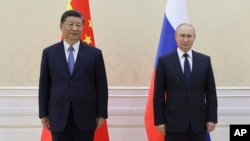 Chinese President Xi Jinping, left, and Russian President Vladimir Putin pose for a photo on the sidelines of the Shanghai Cooperation Organisation summit in Samarkand, Uzbekistan, Sept. 15, 2022. (Sputnik, Kremlin Pool photo via AP)