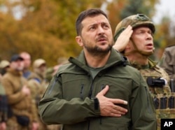 Presiden Ukraina Volodymyr Zelenskyy menyanyikan lagu kebangsaan Ukraina selama kunjungannya ke kota Izium, wilayah Kharkiv, Ukraina, 14 September 2022. (Foto: via AP)