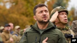 Kantor Pers Kepresidenan Ukraina, Presiden Ukraina Volodymyr Zelenskyy menyanyikan lagu kebangsaan Ukraina saat kunjungannya ke Kota Izium, wilayah Kharkiv, Ukraina, 14 September 2022. (Foto: via AP)