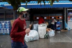 Seorang pelari mengenakan masker saat melewati pusat daur ulang di wilayah Brooklyn, New York, AS, di tengah pandemi COVID-19, 13 Oktober 2020.