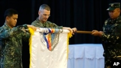 Wakil Panglima Angkatan Laut Filipina, Alexander Lopez (kiri) dan Brigjen Marinir AS Christopher Mahoney (tengah) membuka gulungan bendera Balikatan dalam upacara pembukaan latihan militer gabungan tentara Amerika dan Filipina "Balikatan 2015", 20 April 2015 (Foto: AP Photo/Bullit Marquez)