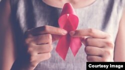 ILUSTRACIJA - Žena drži ružičastu mašnicu, simbol podizanja svesti o raku dojke 