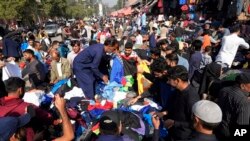 Warga Pakistan berbelanja di Lahore, Pakistan, Senin, 13 November 2022. Populasi dunia diproyeksikan mencapai sekitar 8 miliar orang pada Selasa, 15 November, menurut proyeksi PBB. (AP/K.M. Chaudary)