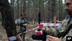 负责特殊情况下失踪人员事务的专员柯藤科9月15日在刚刚被收复的城市伊久姆察看埋葬着姓名不明的平民和乌克兰军人的坟墓。
Oleg Kotenko, commissioner for issues of missing persons under special circumstances, looks at the unidentified graves of civilians and Ukrainian soldiers in the recently retaken area of Izium, Ukraine, Sept. 15, 2022.