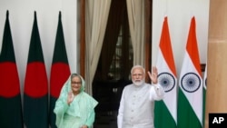 印度总理莫迪和孟加拉国总理谢赫·哈西娜（Sheikh Hasina）在会谈前向等待的媒体挥手致意。（2022年9月6日）