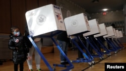 Adelaide Hart, 5, menunggu ibunya Davina Moore memberikan suara di wilayah Manhattan di New York City, AS, 3 November 2020. (Foto: REUTERS/Andrew Kelly)