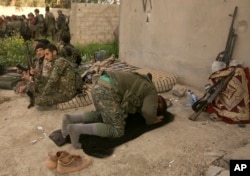 A U.S.-backed Syrian Democratic Forces fighter prays after returning from the front line in their fight against Islamic State militants in Baghuz, Syria, March 19, 2019.