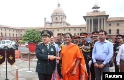 中国国防部长魏凤在新德里与印度国防部长西塔拉曼握手（2018年8月23日）