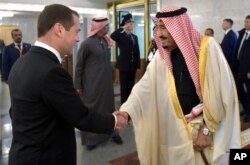 Russian Prime Minister Dmitry Medvedev, left, shakes hands with Saudi Arabia's King Salman during a meeting in Moscow, Russia, Oct. 6, 2017.