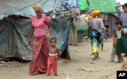 Rosmaida Bibi walks with the help of her mother at the camp. It's hard, her mother says, because Rosmaida's tiny joints often hurt. She can't walk far, and she's never been able to run.
