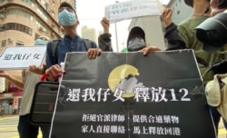 多名被关押盐田看守所的港人家属9月30日手持写上4大诉求的标语，由西区警署游行到北京驻港机构中联办外请愿，要求释放12港人 （美国之音/汤惠芸）
