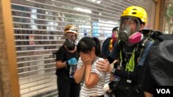 有市民不知道警方在德福花园商场施放催泪弹驱散示威者，被催泪烟波及，双眼刺痛，由示威者护送到安全地点 (摄影：美国之音汤惠芸)