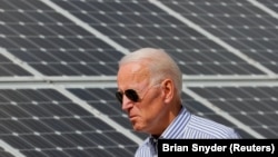Joe Biden, yang saat itu masih kandidat presiden, berjalan melintas panel surya saat mengunjungi Insitiatif Energi Terbarukan Kawasan Plymouth, di New Hampshire, 4 Juni 2019. (Foto: Brian Snyder/Reuters)