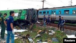 ក្រុម​ការងារ​ជួយ​សង្គ្រោះ​ឈរ​នៅ​កន្លែង​ដែល​គ្រោះថ្នាក់​ចរាចរណ៍​កើតឡើង​រវាង​រថយន្ដ​ដឹក​អ្នក​ដំណើរ​មួយ​គ្រឿង និង​រថភ្លើង​មួយ​គ្រឿង នៅ​ខេត្ត Chacheongsao ចំ​កណ្ដាល​ប្រទេស​ថៃ ថ្ងៃទី១១ ខែតុលា ឆ្នាំ២០២០។ 