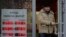 FILE - A man leaves a bank displaying currency exchange rates in Moscow, Dec. 20, 2024. 