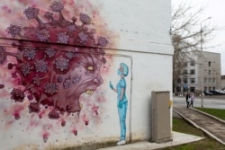A coronavirus mural opposite Kuvatov Republican Clinical Hospital after a mass infection incident in Ufa, Russia, on April 25, 2020. (Vadim Braifov/TASS)