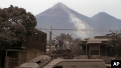 Petugas penyelamat memeriksa rumah-rumah warga yang ditutupi oleh abu vulkanik pasca letusan gunung Volcan de Fuego di Escuintla, Guatemala, Senin (4/6). 