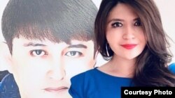 FILE - Rayhan Asat stands in front a photo of her brother, Ekpar Asat. U.S. and U.K. diplomats have joined forces to demand the release of the Uyghur businessman, who has been detained in China since April 2016 after a trip to the U.S. 