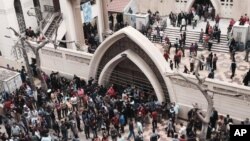 Kerabat dan masyarakat berkumpul di luar sebuah gereja pasca serangan bom pada perayaan Minggu Palem di kota Tanta, Mesir, 9 April 2017. (AP Photo/Nariman El-Mofty)