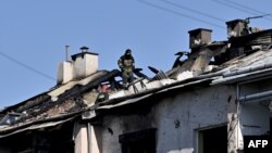 Spasilac na krovu stambene zgrade oštećene u napadu na Lavov, u zapadnoj Ukrajini, 15. avgusta 2023. 