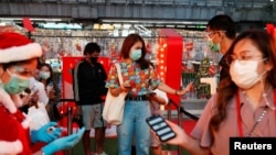 Para pengunjung diperiksa suhu tubuh saat mengunjungi festival lampu Natal di Bangkok, Thailand, 21 Desember 2020. 