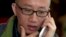 FILE - Chinese dissident Hu Jia talks on his phone during a meeting at a restaurant in Beijing, April 10, 2013.