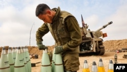 Pripadnik izraelskih artiljerijskih snaga priprema granate, nedaleko od granice Pojasa Gaze, 5. decembra 2023. (Foto: AFP/Gil Cohen-Magen)