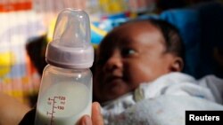 Seorang ibu di Jakarta, tengah memegang botol susu anaknya, 7 Agustus 2012. (Foto: ilustrasi). 