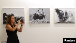 Seorang pengunjung mengambil foto karya-karya seni yang dipamerkan di Art Dubai, di Dubai, Uni Emirat Arab, 21 Maret 2018.