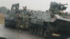 Soldiers stand beside military vehicles just outside Harare, Zimbabwe, Nov. 14,2017.
