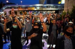 Pro-democracy activists show the three-finger salute during a protest after the constitutional court's ruling on Prime Minister Prayuth Chan-Ocha's conflict of interest case, in Bangkok, Thailand, Dec. 2, 2020.