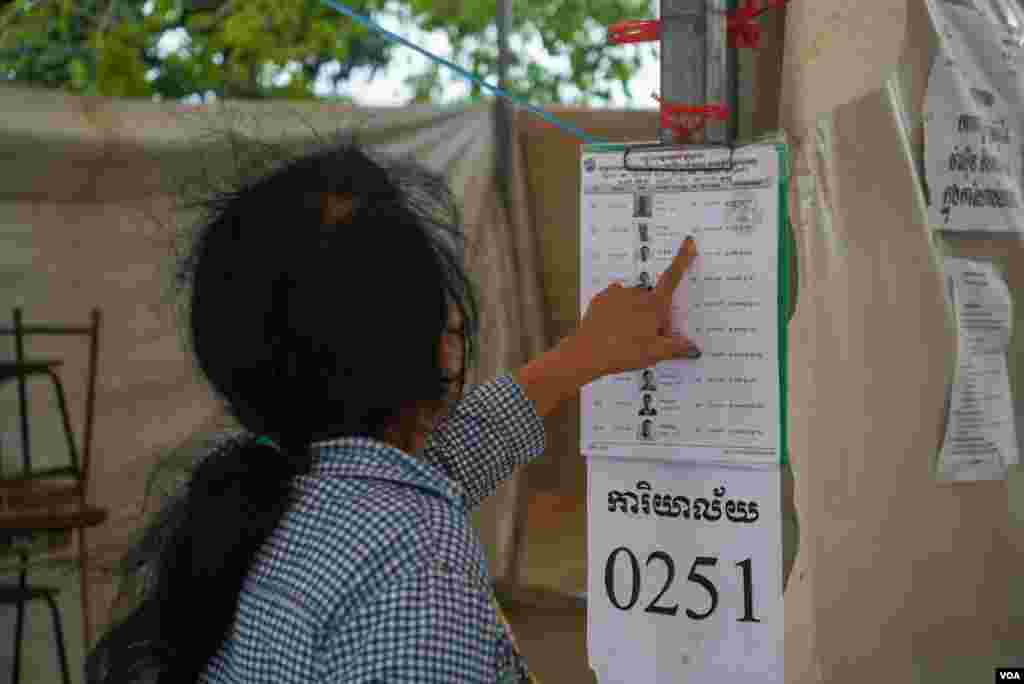 ស្ត្រីម្នាក់ផ្ទៀងផ្ទាត់ឈ្មោះនៅក្នុងបញ្ជីឈ្មោះអ្នកបោះឆ្នោត មួយថ្ងៃមុនថ្ងៃបោះឆ្នោតឃុំសង្កាត់អាណត្តិទី ៥ នៅមណ្ឌលបោះឆ្នោតមួយកន្លែង ក្នុងសង្កាត់ផ្សារកណ្តាលទី ១ ខណ្ឌដូនពេញ រាជធានីភ្នំពេញ ថ្ងៃសៅរ៍ ទី ៤ ខែមិថុនា ឆ្នាំ ២០២២។ (ខាន់ សុគុំមនោ/វីអូអេ)