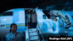 Putri Diego Maradona, Dalma, dan Yanina, di depan pesawat yang didedikasikan untuk mendiang legenda sepak bola di Buenos Aires, Argentina, Rabu, 25 Mei 2022. (Foto: AP )