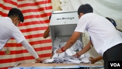 នៅ​មណ្ឌល​បោះឆ្នោត​មួយ​ក្នុង​សង្កាត់​បឹងព្រលិត​ ខណ្ឌ៧មករា​ មន្រ្តីរៀបចំការបោះឆ្នោត​ចាក់​សន្លឹកឆ្នោត​ចេញពីហិបឆ្នោត​ រាជធានីភ្នំពេញ ​ថ្ងៃទី០៥ ខែមិថុនា ឆ្នាំ២០២២។ (ខាន់ សុគុំមនោ/វីអូអេ)