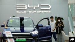 People visit a Chinese automaker BYD store on Wednesday, March 16, 2022, in Beijing.
