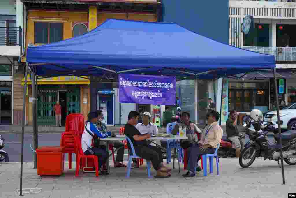 ក្រុមការងារការពារការិយាល័យបោះឆ្នោតមានវត្តមាននៅមណ្ឌលបោះឆ្នោតមួយកន្លែង មួយថ្ងៃមុនថ្ងៃបោះឆ្នោតឃុំសង្កាត់អាណត្តិទី ៥ ក្នុងសង្កាត់ផ្សារកណ្តាលទី ១ ខណ្ឌដូនពេញ រាជធានីភ្នំពេញ ថ្ងៃសៅរ៍ ទី ៤ ខែមិថុនា ឆ្នាំ ២០២២។ (ខាន់ សុគុំមនោ/វីអូអេ)