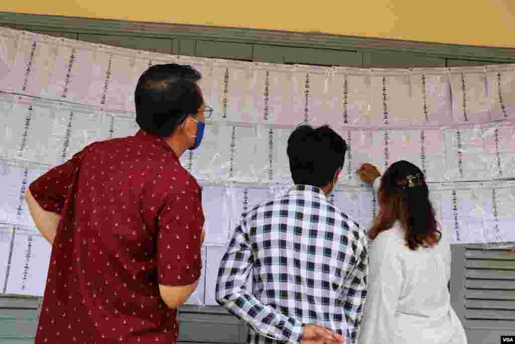 ប្រជាពលរដ្ឋ​ រក​មើល​ឈ្មោះ​ក្នុង​បញ្ជីឈ្មោះ​បោះ​ឆ្នោត នៅ​ការិយាល័យ​បោះ​ឆ្នោត​អូរ​តាគាំ១​ ក្នុង​ក្រុង​បាត់​ដំបង នៅ​ថ្ងៃទី០៥ ខែមិថុនា ឆ្នាំ២០២២។ (លាស់ លីបលីប​/​វីអូអេ) 