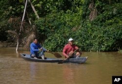 Dua pria pribumi mendayung di Sungai Itaquai mencari jurnalis Inggris Dom Phillips dan pakar urusan Pribumi Bruno Araujo Pereira di wilayah Adat Lembah Javari, Atalaia do Norte, negara bagian Amazonas, Brazil, 9 Juni 2022. (Foto: AP)