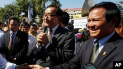 FILE PHOTO - Opposition leader of Cambodia National Rescue Party Sam Rainsy, center, delivers a speech next to his Deputy President Kem Sokha, right, during a gathering to mark Human Rights Day, in front of National Assembly, in Phnom Penh, Cambodia.