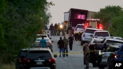 Police and other first responders work the scene where officials say dozens of people have been found dead and multiple others were taken to hospitals with heat-related illnesses after a semitrailer containing suspected migrants was found, Monday, June 27