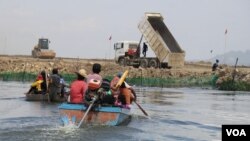 ប្រជាពលរដ្ឋ ជិះទូក​ទៅកាន់​កន្លែង​គ្រឿង​ចក្រ​កំពុង​ចាក់​ថ្ម​ចូល​បឹង​តាមោក ដែល​ចំ​កន្លែង​ពួកគេ​ចិញ្ចឹម​ត្រី ក្នុង​សង្កាត់​សំរោង​ត្បូង​ ​ខណ្ឌ​ព្រែក​ព្នៅ​ ​រាជ​ធានី​ភ្នំពេញ ថ្ងៃទី២៧ ខែមិថុនា ឆ្នាំ២០២២។ (ហាន ណូយ/វីអូអេ)