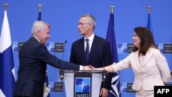 Menteri Luar Negeri Finlandia Pekka Haavisto berjabat tangan dengan Menteri Luar Negeri Swedia Ann Linde didampingi Sekretaris Jenderal NATO Jens Stoltenberg (tengah) seusai konferensi pers di Brussels, 5 Juli 2022.