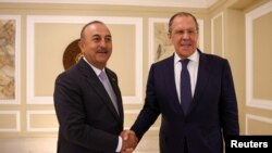 Menlu Rusia Sergei Lavrov dan Menlu Turki Mevlut Cavusoglu berjabat tangan saat bertemu di Denpasar, 7 Juli 2022. (Kementerian Luar Negeri Rusia/Handout via REUTERS)