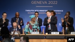 Direktur Jenderal Organisasi Perdagangan Dunia Ngozi Okonjo-Iweala (tengah) berdiri di samping ketua konferensi Timur Suleimenov (kedua dari kanan) pada sesi penutupan Konferensi Tingkat Menteri di markas WTO di Jenewa, 17 Juni 2022. (Foto:Fabrice COFFRINI / POOL / AFP)