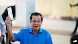 FILE - Perdana Menteri Kamboja Hun Sen, dari Partai Rakyat Kamboja (CPP), memegang surat suaranya sebelum memasukkannya ke dalam kotak suara di sebuah TPS di Takhmua, provinsi Kandal, tenggara Phnom Penh, Kamboja, 5 Juni 2022.