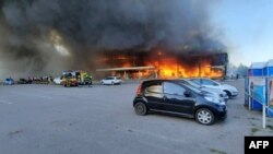 Petugas damkar berusaha memadamkan kobaran api setelah serangan rudal Rusia menghantam sebuah mal di kota Kremenchuk, Ukraina tengah Senin (27/6).
