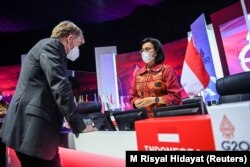 Menteri Keuangan Sri Mulyani Indrawati berbicara kepada Direktur Jenderal Organisasi Kesehatan Dunia (WHO) Bruce Aylward usai penutupan rapat menteri keuangan dan gubernur bank sentral G20 di Jakarta, 18 Februari 2022. (Foto: M Risyal Hidayat via REUTERS