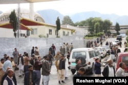 Earthquake-stricken Kashmiris gather outside their offices in Muzaffarabad after a 7.5-magnitude temblor rattled Pakistan and Kashmir, Oct. 26, 2015.