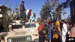 Pejuang Taliban berjaga-jaga di sepanjang pinggir jalan di Herat, kota terbesar ketiga di Afghanistan, 13 Agustus 2021. (AFP)
